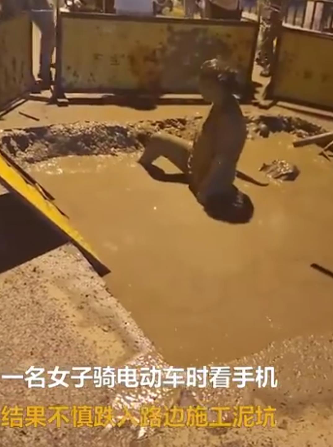 女子骑车看手机跌泥坑执着捞手机